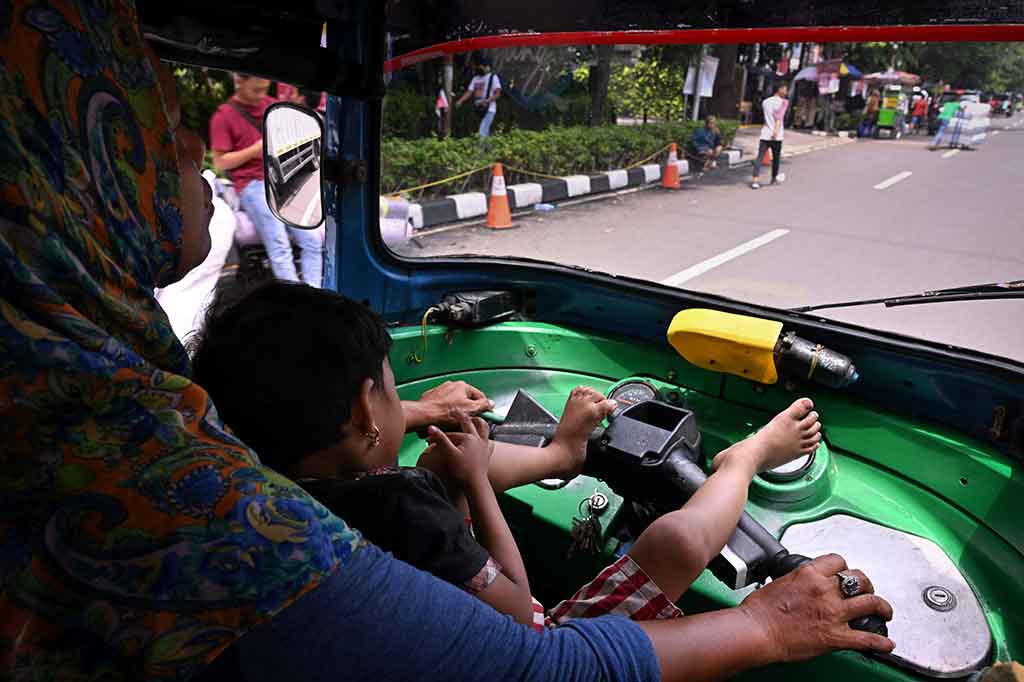 Bersama putrinya yang berusia tiga tahun, ibu tunggal, Ekawati, mengarungi lalu lintas Jakarta yang terkenal buruk dengan bajaj untuk mencari nafkah, sebagai salah satu dari semakin banyak perempuan Indonesia yang menekuni pekerjaan informal di luar rumah.