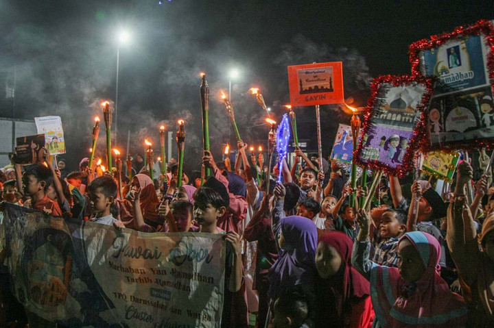 Ratusan anak-anak membawa obor dan juga sejumlah poster unik yang berisi ucapan dalam rangka menyambut bulan suci Ramadan.
