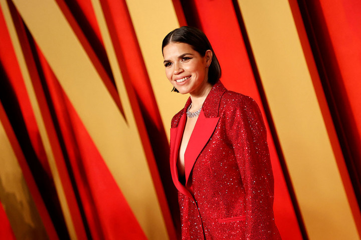 America Ferrera, nominasi aktris pendukung terbaik untuk perannya dalam Barbie, memadukan dua tren karpet merah dengan gaun Versace tanpa lengan yang pas bentuknya -- berwarna metalik dan merah muda.
