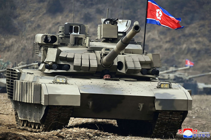 Pemimpin Korea Utara Kim Jong Un mengemudikan tank tempur utama tipe baru sambil mengawasi latihan militer di lokasi yang dirahasiakan, Rabu, 13 Maret 2024.