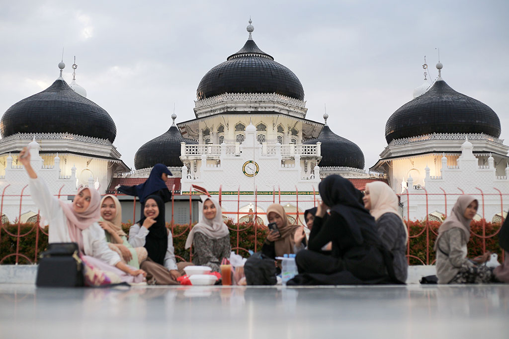 Sambil menunggu waktu berbuka tiba, para jemaah memperhatikan langit yang mulai memerah dan berubah menjadi palet warna-warni yang memukau sambil bersua foto. Suasana ini tidak hanya menakjubkan secara visual tetapi juga membangkitkan kedekatan spiritual di antara para jamaah yang hadir.