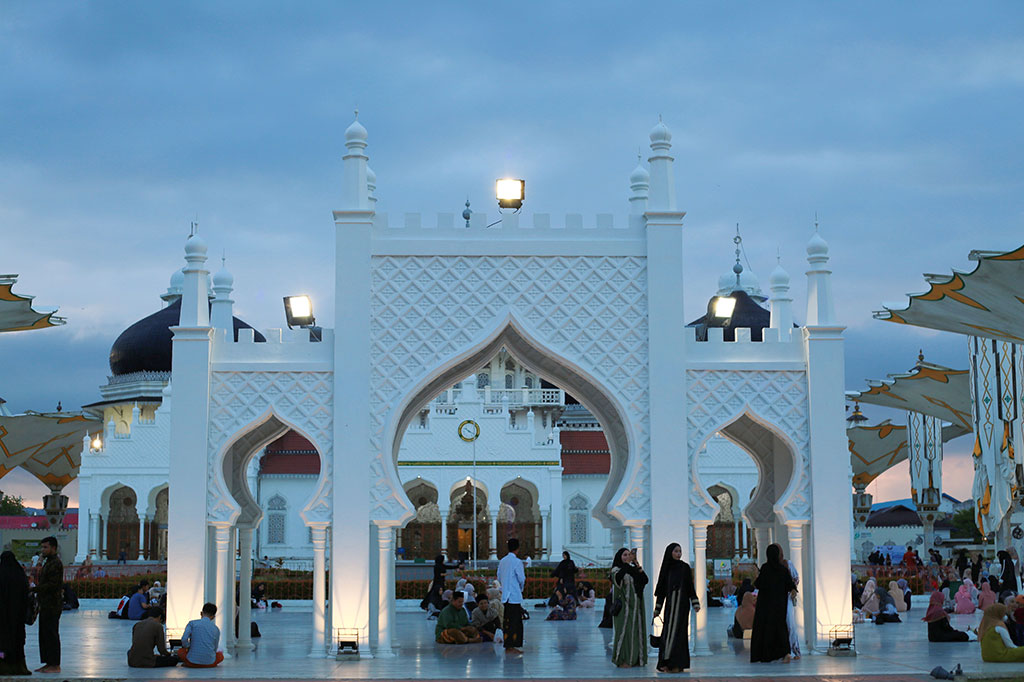 Ketika azan berkumandang, menandakan waktu berbuka telah tiba, suasana semakin khidmat. Para jemaah bersama-sama membatalkan puasa dengan bekal yang mereka bawa, diiringi dengan doa syukur atas nikmat yang diberikan Allah. Suasana kebersamaan yang hangat dan penuh keakraban terasa begitu kuat di pekarangan masjid ini.