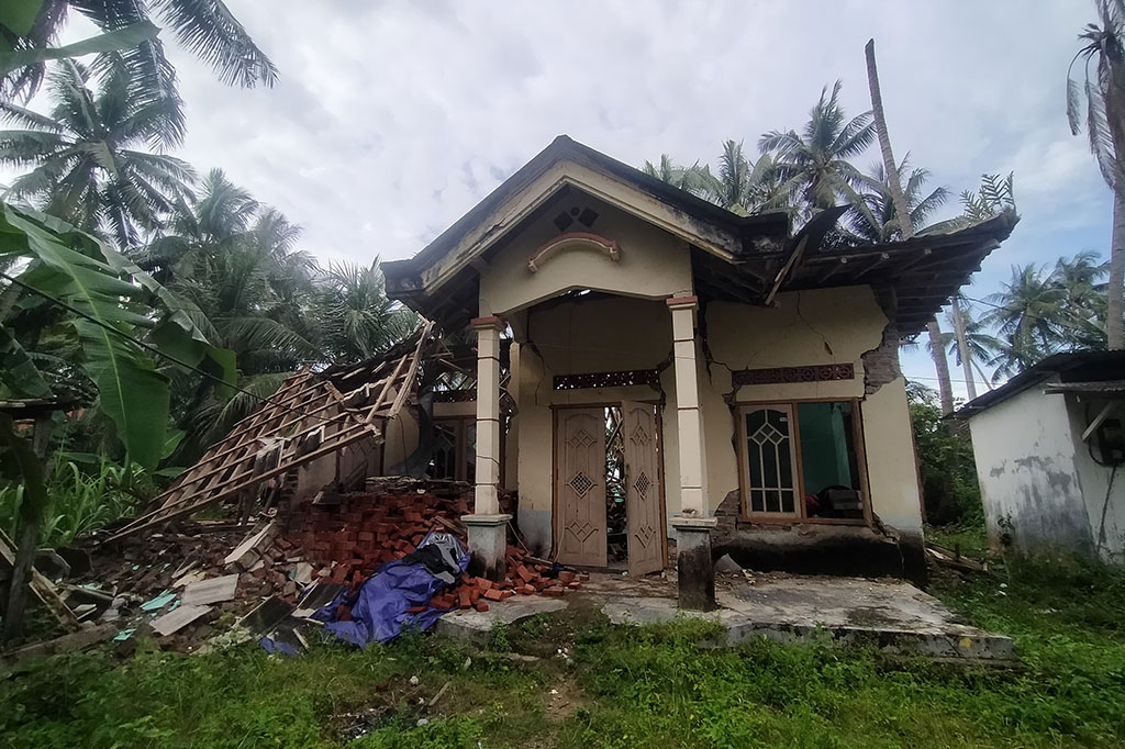 Sebuah rumah warga hancur nyaris rata dengan tanah dan hanya tersisa pintu dan jendela depan. Di sisi belakang rumah sudah rata dengan tanah.