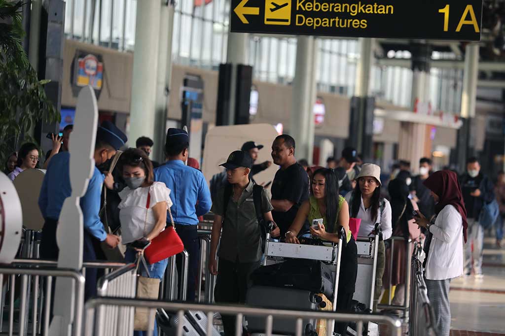 Beberapa penumpang lain, juga terlihat tengah berdiri menunggu pemeriksaan dokumen di sekitar pintu masuk.