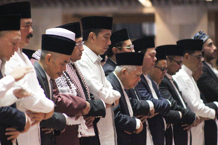 Kepala Negara memakai kemeja putih lengan panjang dengan sarung berwarna hitam. Jokowi bersebelahan dengan Wakil Presiden (Wapres) Ma'ruf Amin dan Imam Besar Masjid Istiqlal Nasaruddin Umar.