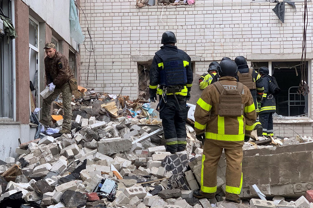 Petugas pertolongan pertama mencari korban yang selamat di reruntuhan dan membawa korban luka dengan tandu ketika genangan darah terbentuk di tanah dekat lokasi serangan, menurut gambar resmi.
