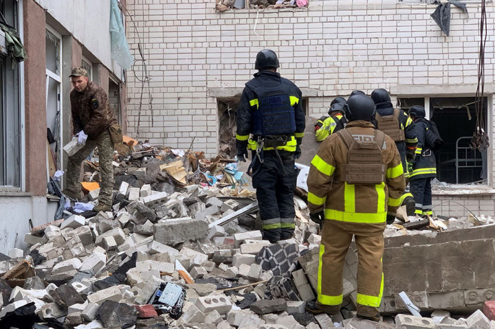 Petugas pertolongan pertama mencari korban yang selamat di reruntuhan dan membawa korban luka dengan tandu ketika genangan darah terbentuk di tanah dekat lokasi serangan, menurut gambar resmi.
