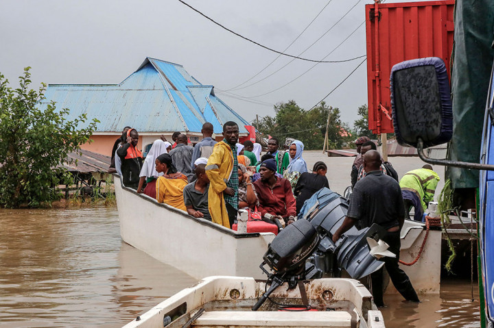 Petugas mengevakuasi warga dengan perahu di daerah yang terkena dampak banjir parah setelah hujan lebat di desa Mohoro, Distrik Rufiji, Tanzania.