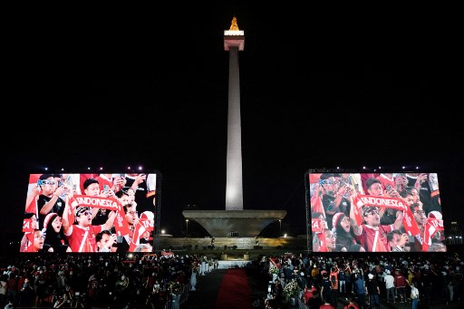 Di kaki tugu Monas, tempat digelarnya nobar, lima buah layar lebar didirikan membelakangi Monas.