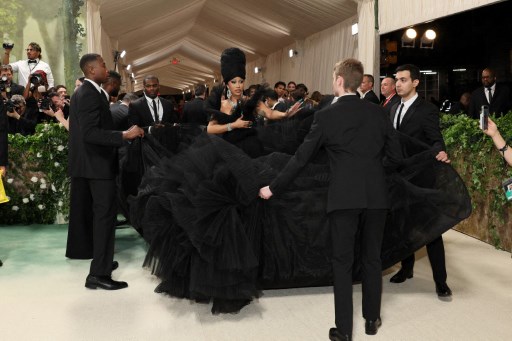 Dia melengkapi penampilan dramatisnya dengan penutup kepala yang serasi berwarna hitam, perhiasan pirus, serasi dengan kuku hijaunya yang setajam belati.