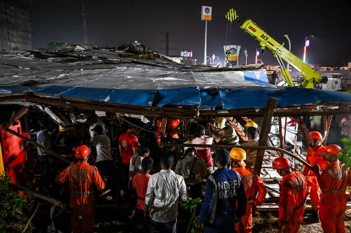 Personil Pasukan Tanggap Bencana Nasional (NDRF) mencari korban selama operasi penyelamatan di lokasi di mana papan iklan roboh setelah dihantam badai debu di Mumbai, India, Senin, 13 Mei 2024.