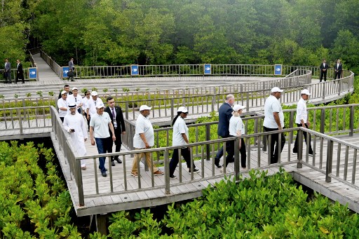 Jokowi mengajak delegasi memasuki area tanaman mangrove yang terletak di sepanjang muara yang didukung dengan teknologi kelistrikan berpembangkit tenaga surya.