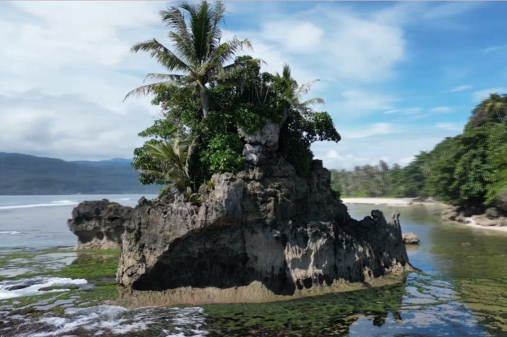 Terletak di wilayah paling utara Pulau Pisang, pantai ini menyajikan keindahan yang mungkin sulit dilupakan. Pemandangan dua batu karang yang terbentuk secara alami, suara deburan ombak nan syahdu dan pemandangan pasir putih yang cantik menambah keindahan pantai ini.