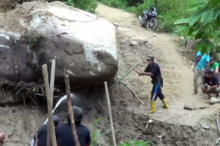 Warga Desa Salu Dengen, Kecamatan Bambang secara swadaya bergotong royong memidahkan bongkahan batu yang berukuran cukup besar yang menutupi badan jalan. Warga memindahkan batu besar dengan cara manual dan menyemprotkan air menggunakan mesin alkom. 