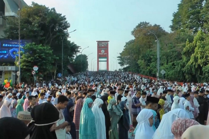 Ribuan umat muslim ini tidak hanya memenuhi halaman Masjid Agung Palembang tetapi juga memenuhi jalan raya di sekitar Masjid hingga Jembatan Ampera. 