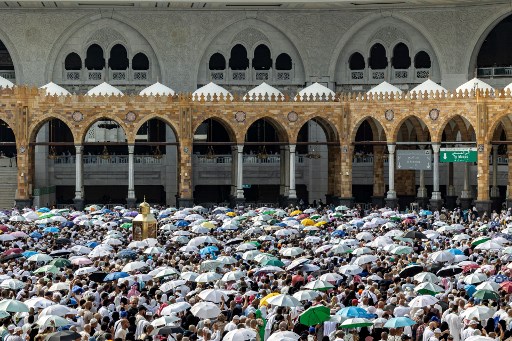 Ribuan jemaah haji mengenakan payung saat tawaf mengelilingi Kakbah, Masjidil Haram, Makkah, Arab Saudi, Selasa, 18 Juni 2024.
