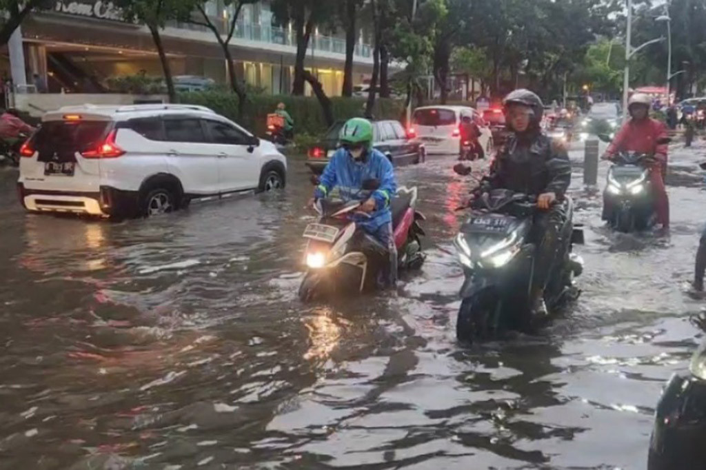 Tak sedikit kendaraan roda dua yang memilih berjalan di trotoar untuk menghindari banjir.
