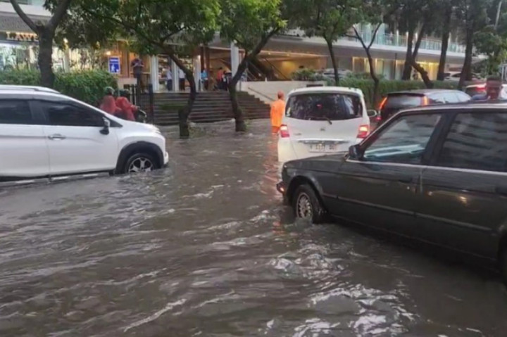 Ketinggian air yang merendam badan jalan mencapai 60 cm hingga membuat arus lalu lintas kendaraan terganggu.