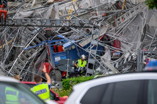 Petugas berada di sekitar perancah yang runtuh dari gedung 19 lantai di Kota Lausanne, Swiss, Jumat, 12 Juli 2024. Sedikitnya tiga orang tewas dan delapan lainnya luka-luka akibat kecelakaan tersebut.