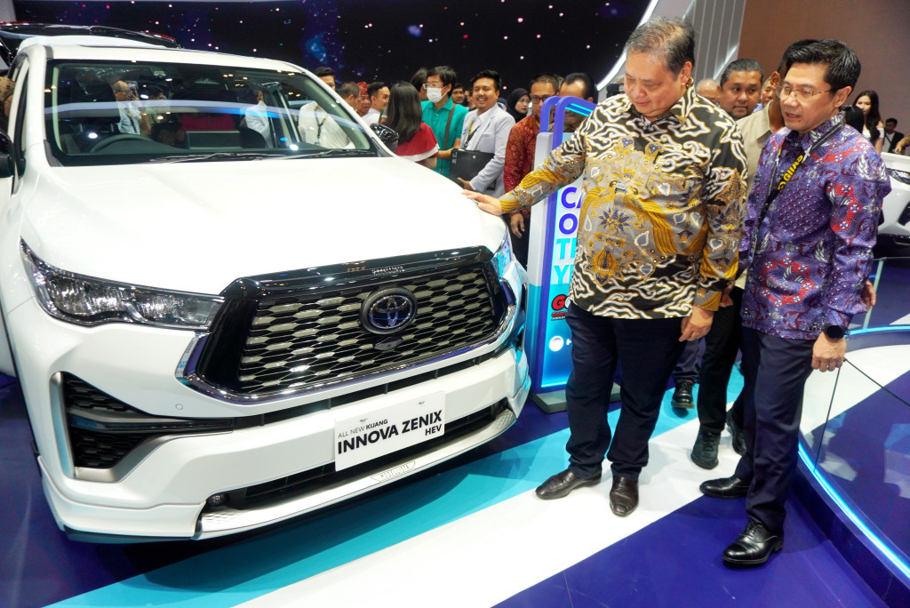 Airlangga juga mengamati dan bertanya-tanya kepada Henry Tanoto dan Widjanarko di depan All New Kijang Innova Zenix Hybrid Electric Vehicle (HEV) yang ditampilkan TAM di booth Toyota. 