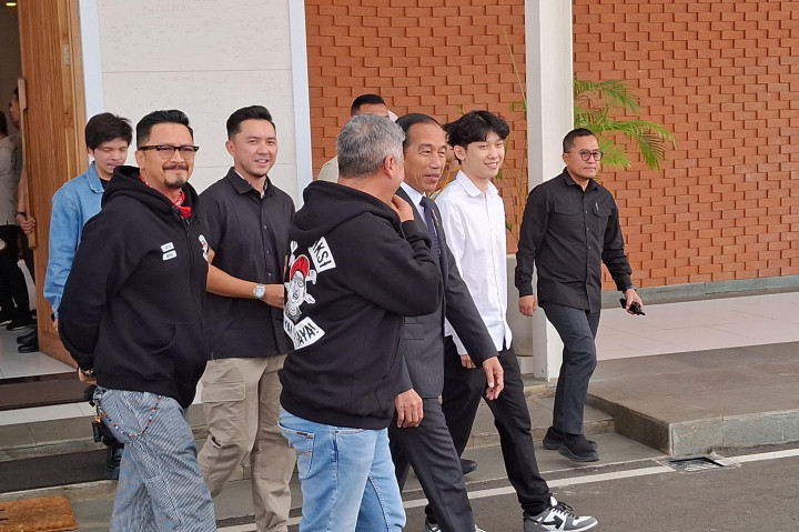 Presiden tampak menggunakan kemeja putih berbalut jas hitam. Presiden juga mengenakan dasi berwarna ungu.