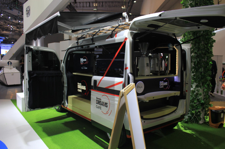 Bagian eksterior, modifikasi dilakukan bagian atap dengan tambahan kanopi, lampu untuk penerangan area luar mobil, kursi dan meja portabel, stiker yang didominasi oleh warna merah dan hitam sebagai representasi dari Dreams Café, serta elemen-elemen pendukung seperti ikon gelas, biji kopi, dan kabel listrik yang melambangkan perpaduan dari mobile café elektrik.