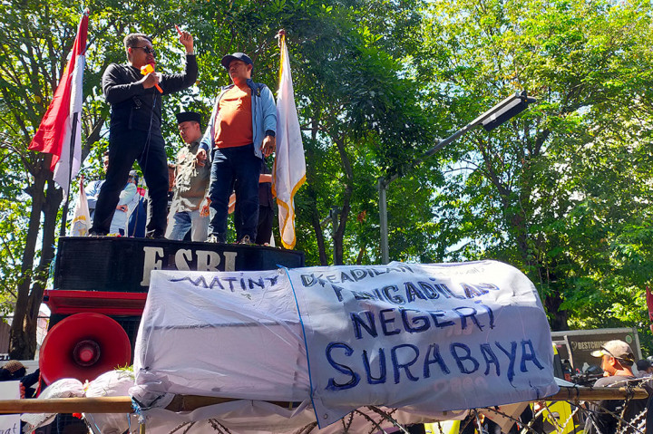 Puluhan warga Jawa Timur melakukan aksi tabur bunga dan membawa keranda bertuliskan matinya keadilan di Pengadilan Negeri Surabaya.