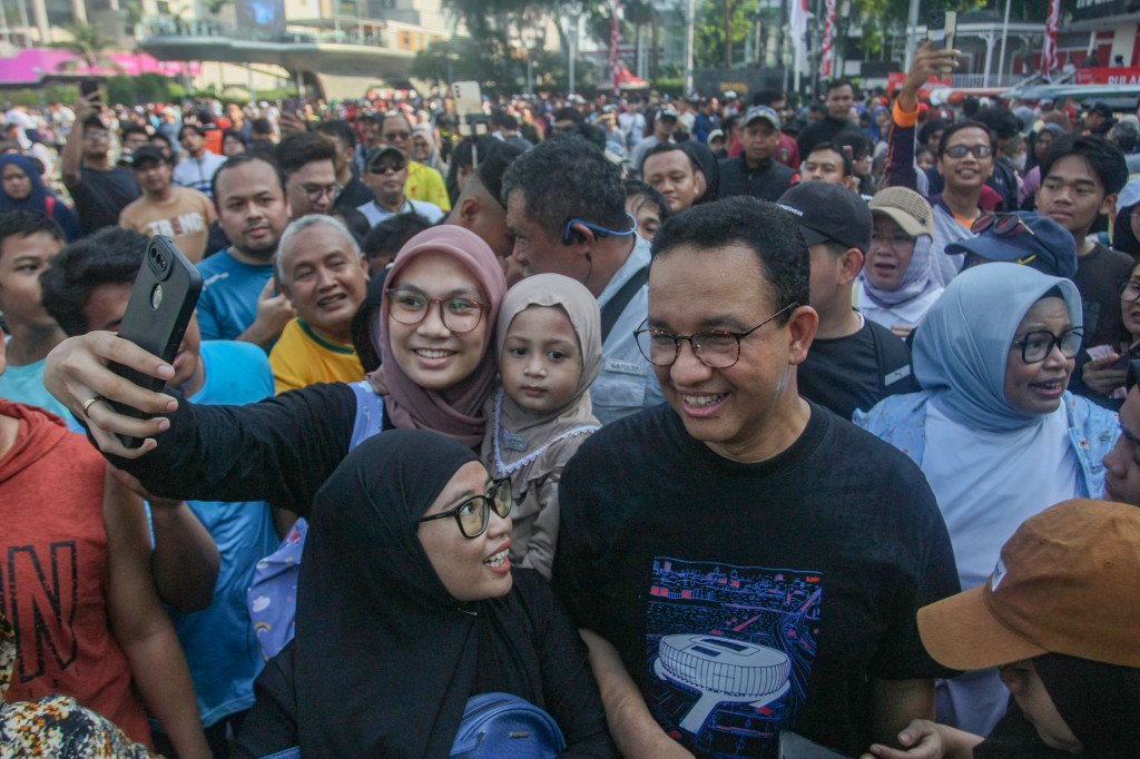Anies bersama istrinya berjalan dari Stasiun MRT Dukuh Atas menuju kawasan Bundara Hotel Indonesia.
