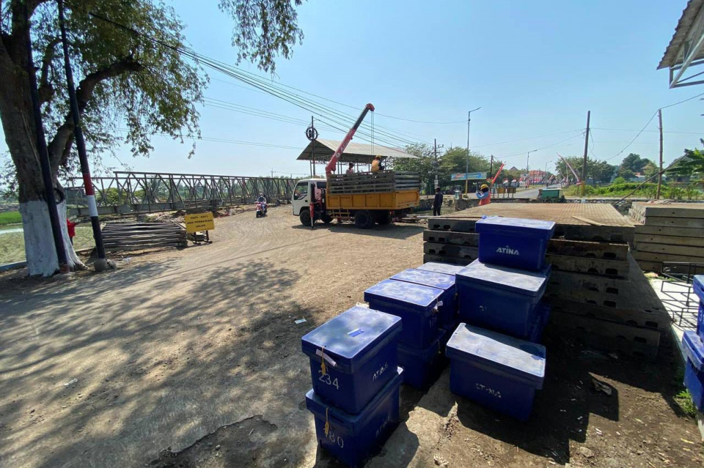 Di sisi utara dam Kedungpeluk, terlihat belasan pekerja sedang merakit rangka jembatan. Panjang rangkaian konstruksi jembatan Bailey sudah tersusun sekitar 10 meter, posisinya membentang antara barat dan timur.