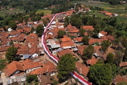 Bendera merah dan putih sepanjang 1000 meter membentang di atas jalan di Kampung Panggilingan, Kecamatan Lemahsugih, Kabupaten Majalengka, Jawa Barat, pada 7 Agustus 2024. 