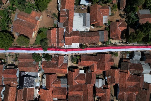 Warga Kampung Penggilingan membentangkan bendera Merah Putih sepanjang satu kilometer di kawasan permukiman guna menyemarakkan HUT ke-79 RI. 
