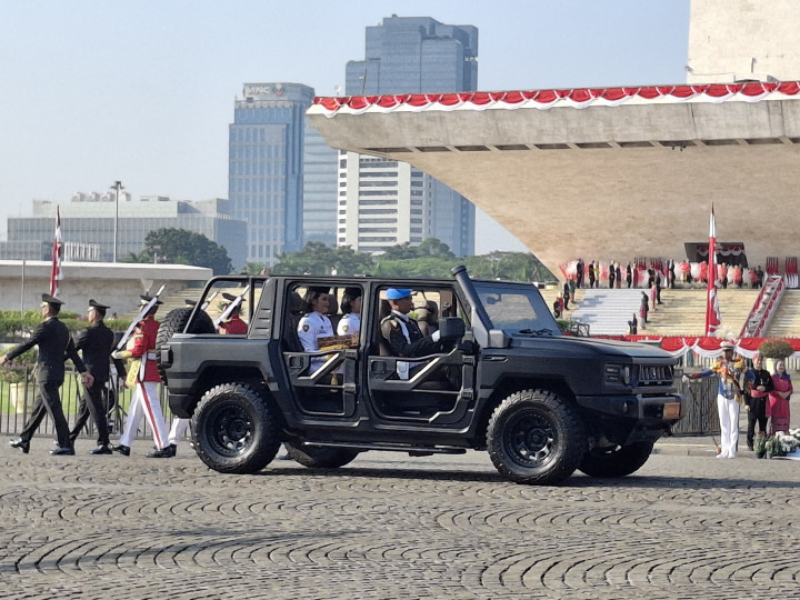 Personel Purna-Paskibraka Kachina Ozora dan Keyla Azzahra Purnama memangku replika bendera Merah Putih dan teks proklamasi di mobil Maung Pindad dalam prosesi kirab dari kawasan Monas menuju Lapangan Udara Halim Perdanakusuma.