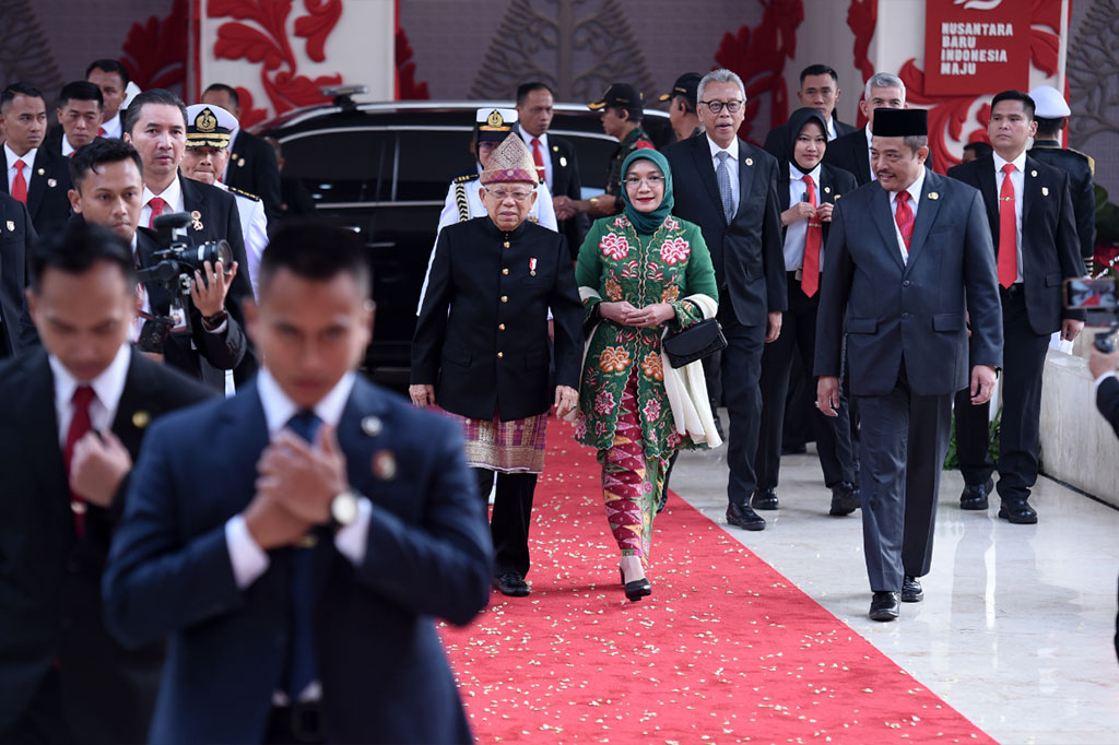 Sementara Wury Ma'ruf Amin mengenakan mengenakan pakaian adat Betawi, Jakarta. Wury tampak mengenakan kebaya Betawi hijau bermotif bunga-bunga dipadukan kerudung yang juga berwarna hijau.