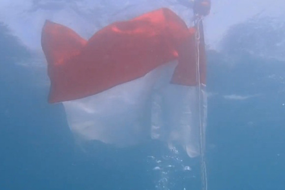Mereka mengibarkan Bendera Merah Putih, di bawah dan permukaan laut di Pulau Semujur, Kabupaten Bangka Tengah, Provinsi Bangka Belitung.