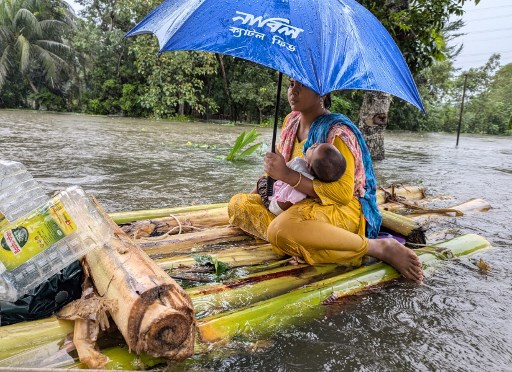 Penduduk Bangladesh mengungsi dengan barang-barang mereka menggunakan perahu dan transportasi darurat lainnya saat air setinggi lutut memasuki rumah mereka.