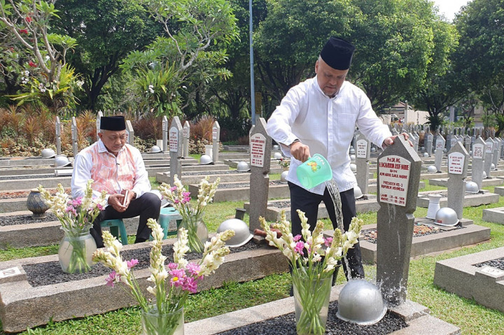 Ilham dan Syaikhu berdoa bersama di samping makam BJ Habibie. Sejumlah peziarah juga ikut dalam suasana khidmat pembacaan doa.