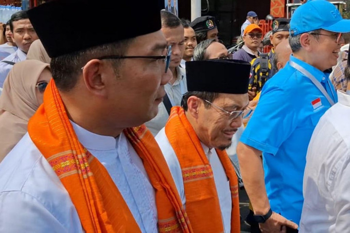 Pantaun Medcom.id, RK dan Suswono kompak mengenakan baju sadariah berwarna putih dan bawahan batik coklat. Keduanya juga menggunakan sarung berwarna oranye yang dikalungkan di leher dan peci hitam. 