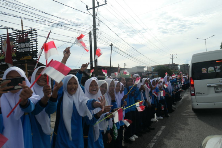 Dengan semangat membara, ribuan pelajar menyanyikan yel-yel dan mengibarkan bendera sambil mengiringi rombongan Kirab Api PON. Antusiasme mereka begitu besar sehingga menciptakan atmosfer yang penuh energi positif.