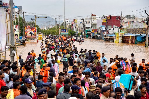 Orang-orang melintasi jalanan yang digenangi banjir setelah hujan lebat musim hujan, di Vijayawada di negara bagian Andra Pradesh, India, Senin, 2 September 2024.