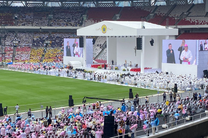 Umat Katolik terlihat memakai baju berwarna-warni sesuai dengan seragam dari masing-masing paroki.