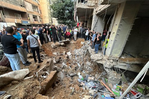 Warga memeriksa kerusakan sebuah gedung di lokasi serangan udara Israel di pinggiran selatan Beirut, Lebanon, Jumat, 20 September 2024. Seorang komandan tinggi Hizbullah di antara 14 korban yang tewas dalam serangan tersebut.
