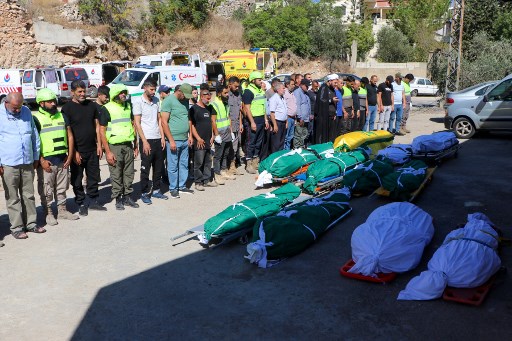 Warga berdoa di atas jenazah anggota keluarga yang tewas dalam serangan udara Israel yang menargetkan desa Jbal el-Botm di Lebanon selatan, menjelang pemakaman mereka, Kamis, 26 September 2024.