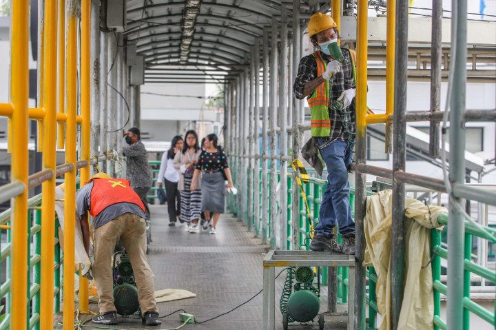 Para pekerja menggarap revitaliasai jembatan penyeberangan orang (JPO) di kawasan Salemba, Jakarta, Rabu, 9 Oktober 2024.