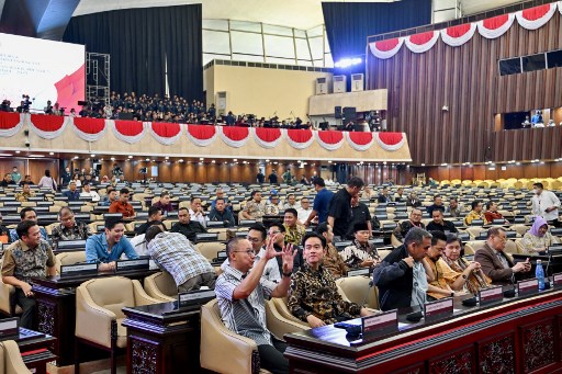 Gibran menggunakan batik coklat lengan panjang saat hadir di Gedung DPR. Pelantikan akan digelar di Ruang Rapat Paripurna I. Belum diketahui apa yang dilakukan Gibran di dalam.