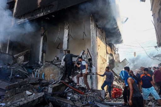 Warga Palestina memeriksa gedung Maghazi Camp Services Club yang hancur setelah serangan Israel terhadap kamp pengungsi Maghazi di Jalur Gaza, Kamis, 24 Oktober 2024.