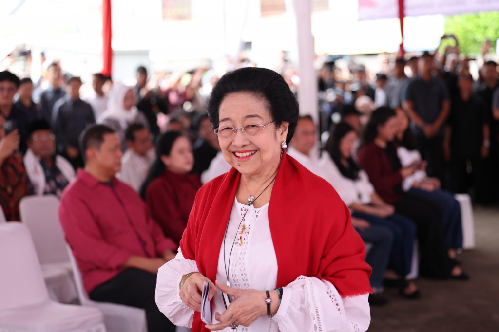 Megawati datang ke TPS dengan tampilan pakaian berwarna putih dengan celana jeans. Dia juga memakai selendang khas.