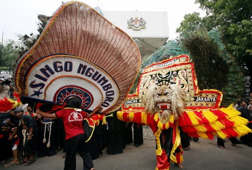 Pertunjukan Reog Ponorogo yang ikonik, dengan pembarong yang membawa Dadak Merak, topeng berbentuk kepala harimau yang dihiasi bulu merak menjadi simbol keberanian dan keindahan seni Indonesia.