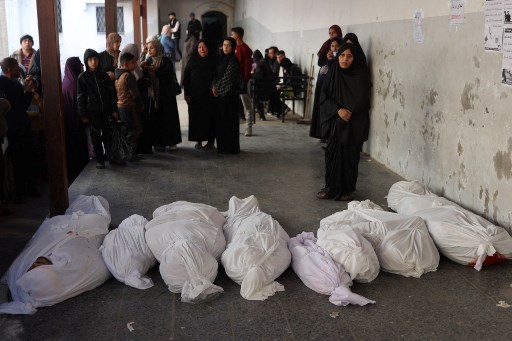 Anggota keluarga berkumpul di sekitar jenazah kerabat yang tewas dalam serangan udara Israel semalam di Kota Gaza, selama persiapan pemakaman mereka di Rumah Sakit Al-Ahli Arab, yang juga dikenal sebagai RS Baptis, pada Kamis, 12 Desember 2024.