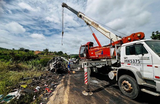 Petugas dibantu alat berat mengevakuasi bangkai kendaraan yang terlibat kecelakaan maut di Teofilo Otoni, negara bagian Minas Gerais, Brasil pada, Sabtu, 21 Desember 2024. 