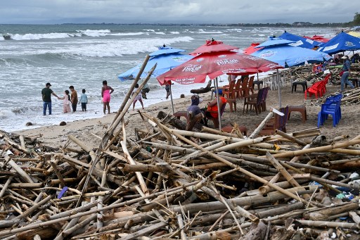 Wisatawan bersantai di dekat tumpukan sampah yang berserakan saat liburan Natal di Pantai Kuta, Badung, Bali, Rabu, 25 Desember 2024. 
